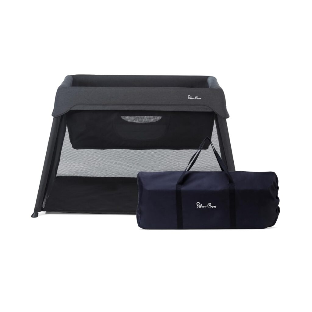 Best Travel Crib for Toddlers in 2026 Silver Cross Slumber Travel Crib in a dark grey charcoal color, shown standing on a white background with its included carry bag.